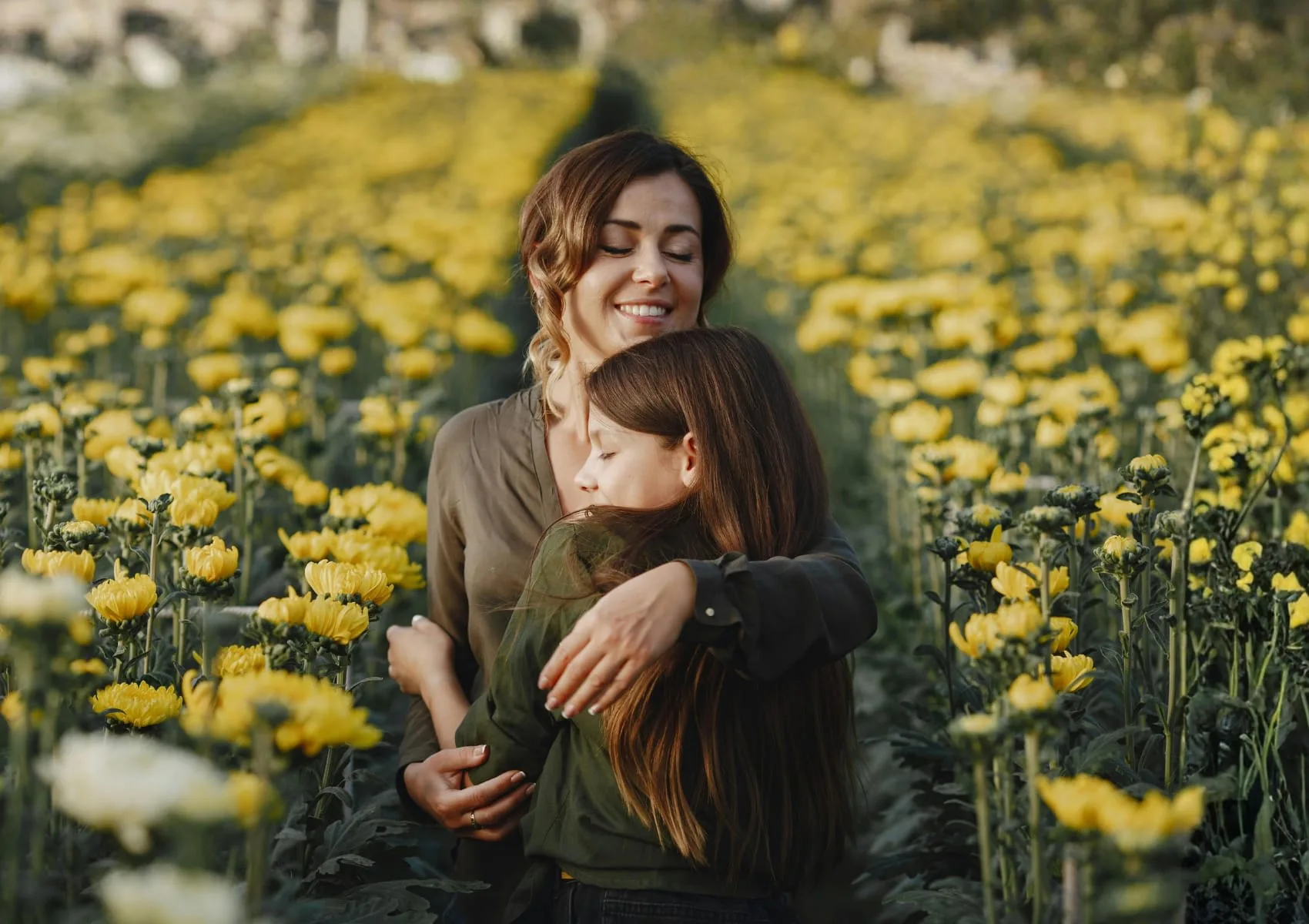 A family sharing a moment in a field of yellow flowers.