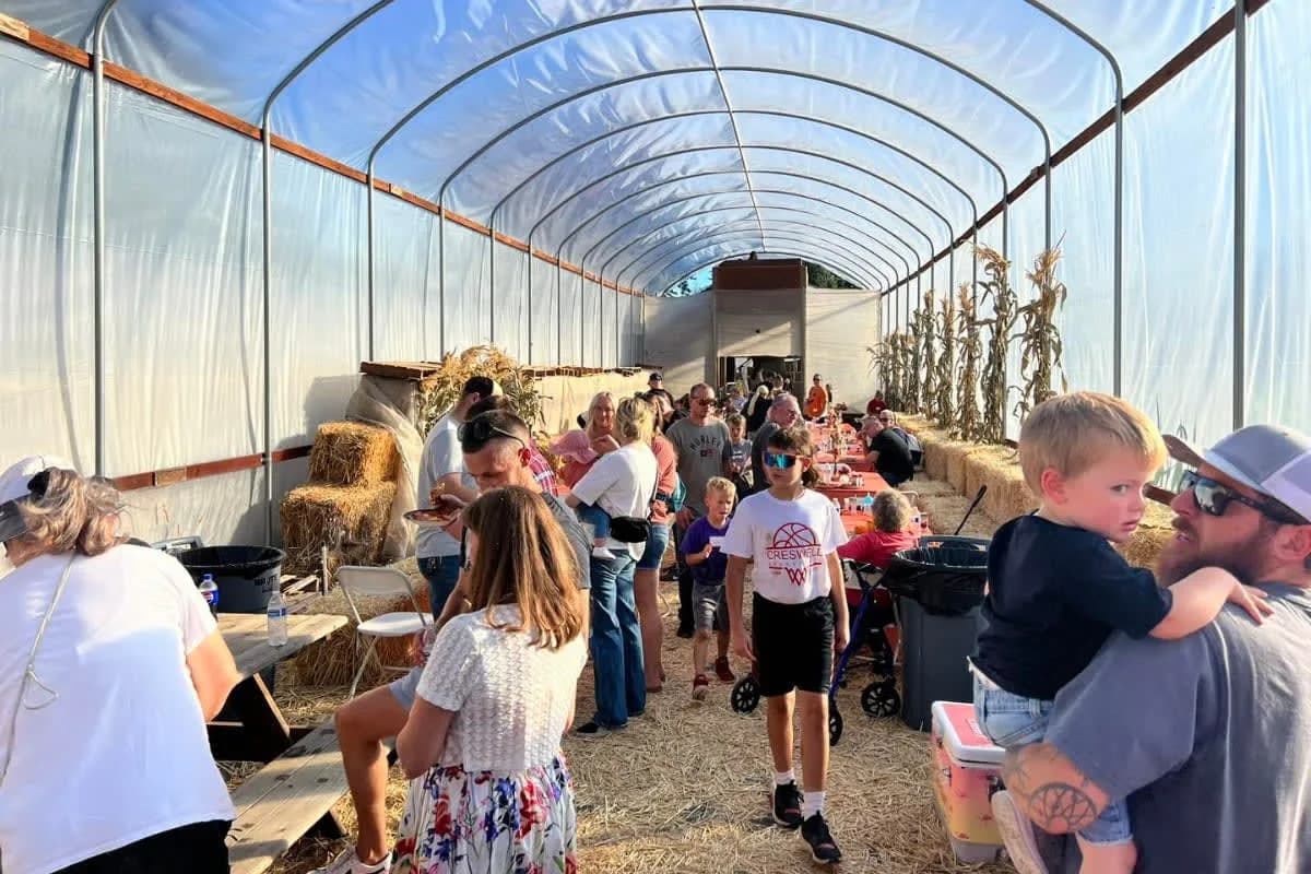 Families walking together through a farm greenhouse.